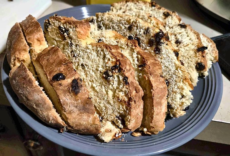 A sliced loaf of Irish soda bread studded with raisins